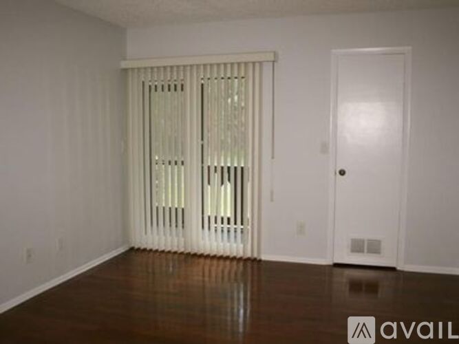 A room with a white door and a window with blinds.