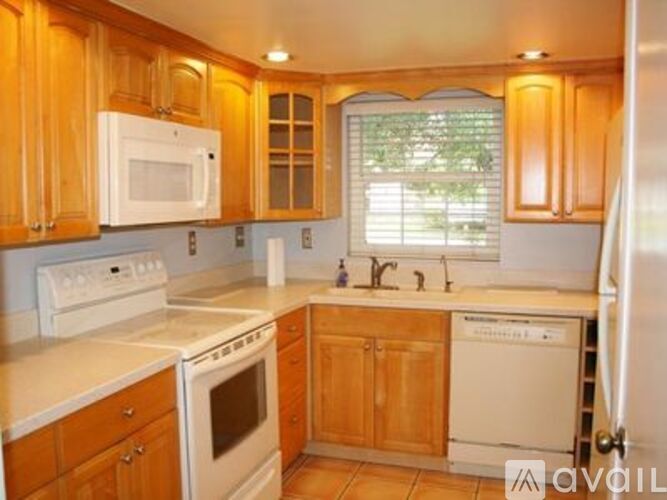 A kitchen with wooden cabinets and white appliances.