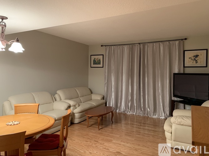 A living room with a grey sofa set and a wooden table.
