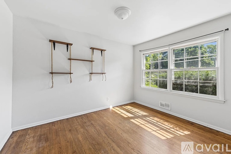 A room with a window and wooden floors.