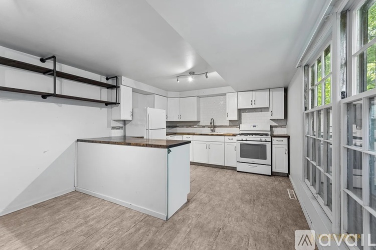 A kitchen with white cabinets and a wooden island.