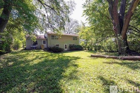 A house is surrounded by trees and grass.