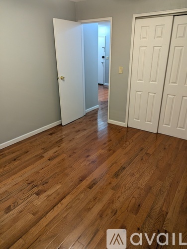 A room with wooden flooring and two doors.