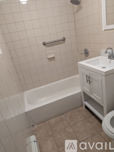 A white bathroom with a tub, sink, and toilet.