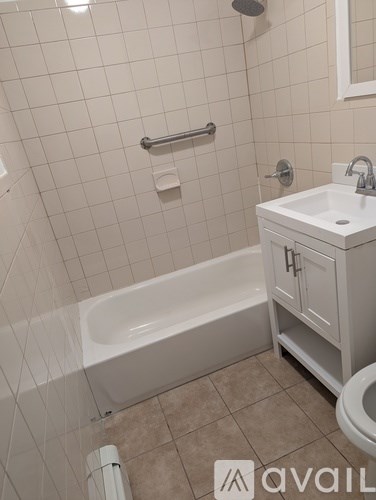 A white bathroom with a tub, sink, and toilet.