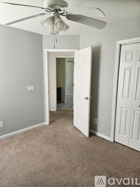 A room with a ceiling fan and two doors.