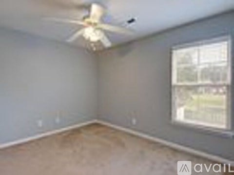 A room with a ceiling fan and a window.