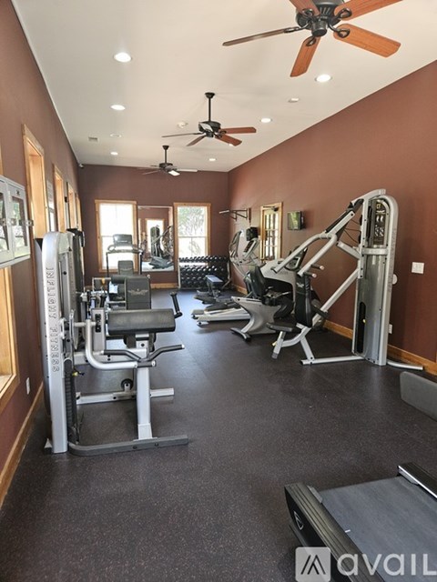 A gym with a variety of equipment including a treadmill, weights, and a bench press.