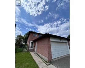 A house with a white garage door and a brick wall.