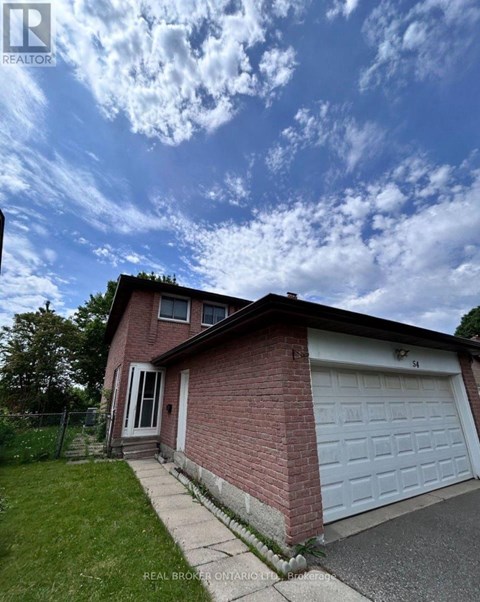 A house with a white garage door and a brick wall.