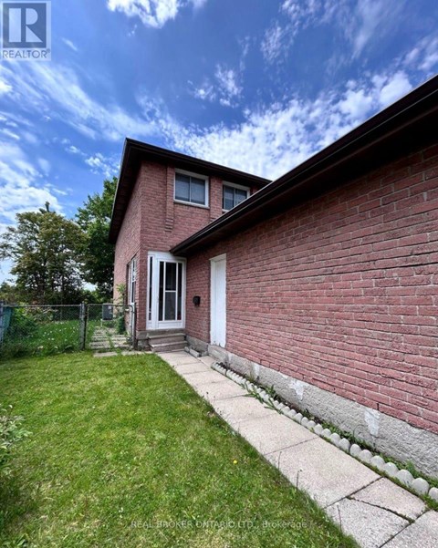 A red brick house with a white door and a small porch.