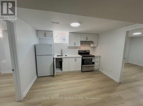 A kitchen with white cabinets and a refrigerator.
