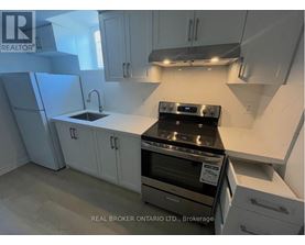 A kitchen with white cabinets and a black stove top oven.