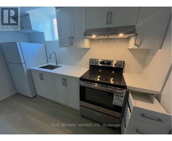A kitchen with white cabinets and a black stove top oven.