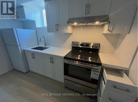 A kitchen with white cabinets and a black stove top oven.