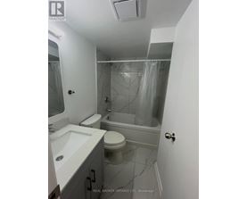 A bathroom with a toilet, sink, and bathtub.