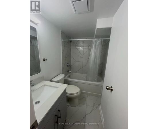 A bathroom with a toilet, sink, and bathtub.