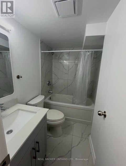 A bathroom with a toilet, sink, and bathtub.
