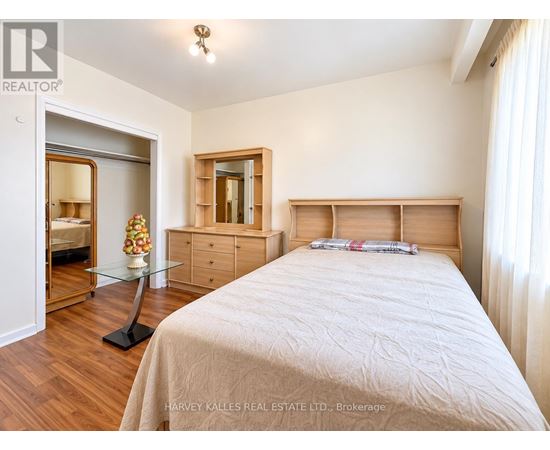 A bedroom with a bed, dresser, and mirror.