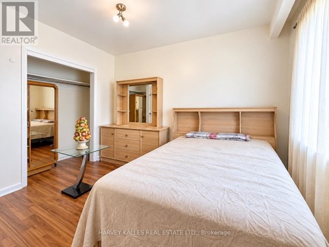 A bedroom with a bed, dresser, and mirror.