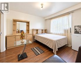 A bedroom with a bed, a dresser, and a mirror.