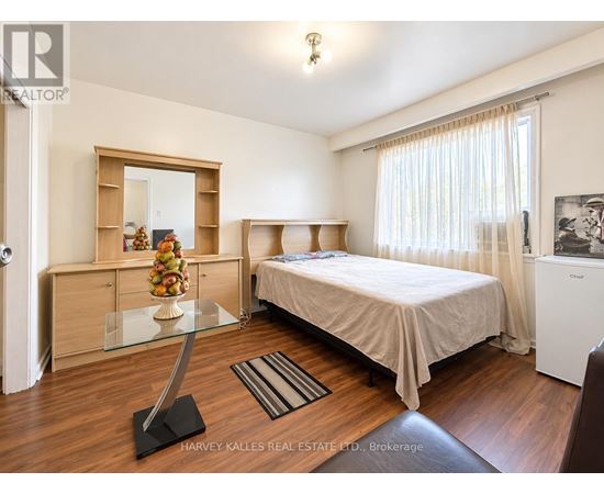 A bedroom with a bed, a dresser, and a mirror.