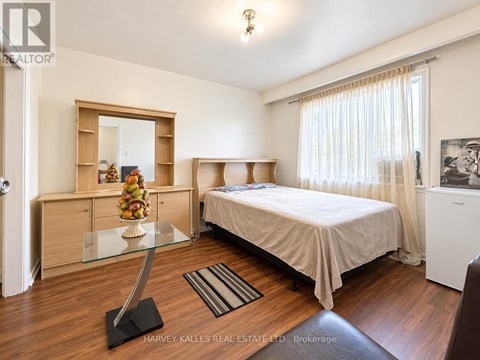 A bedroom with a bed, a dresser, and a mirror.