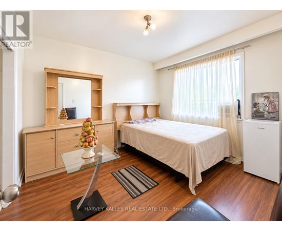 A bedroom with a bed, dresser, and mirror.