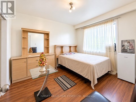 A bedroom with a bed, dresser, and mirror.
