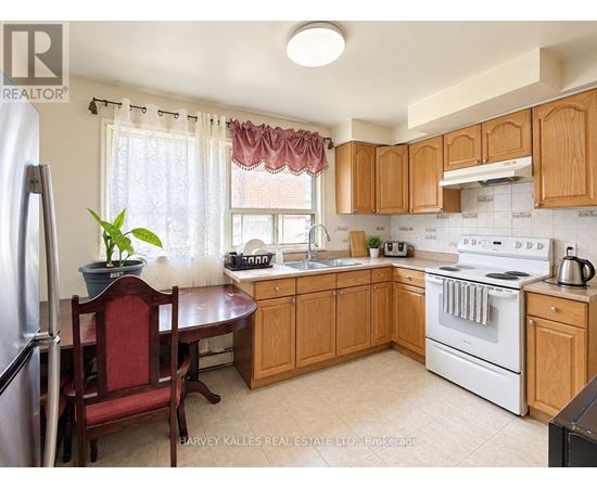 A kitchen with wooden cabinets and a red chair.