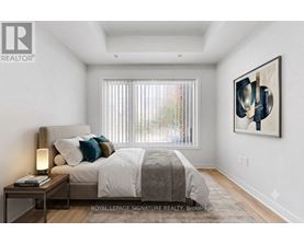 A bedroom with a large bed and a painting on the wall.