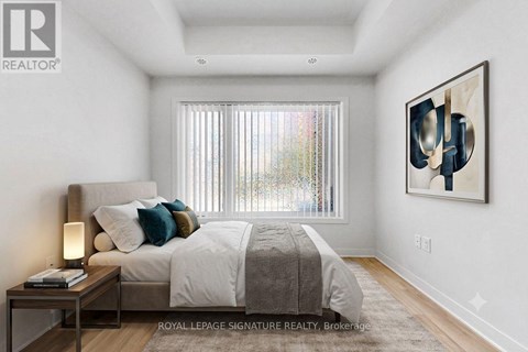 A bedroom with a large bed and a painting on the wall.