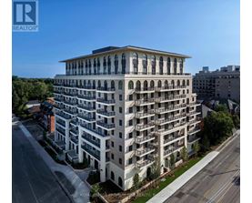 A large, white, multi-story building with balconies and arched windows.
