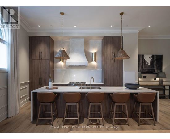 A modern kitchen with a central island and bar stools.