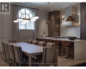 A dining room with a large table and chairs.