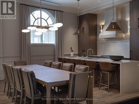 A dining room with a large table and chairs.