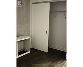 A white closet door with a white bench below it.