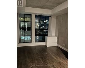 A room with a large window and wooden flooring.