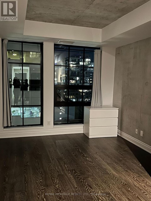 A room with a large window and wooden flooring.
