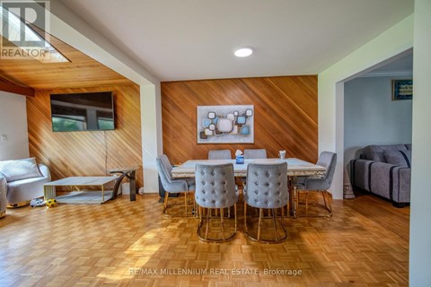 A dining room with a wooden table and chairs.