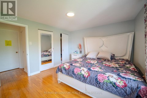 A bedroom with a bed and a floral comforter.