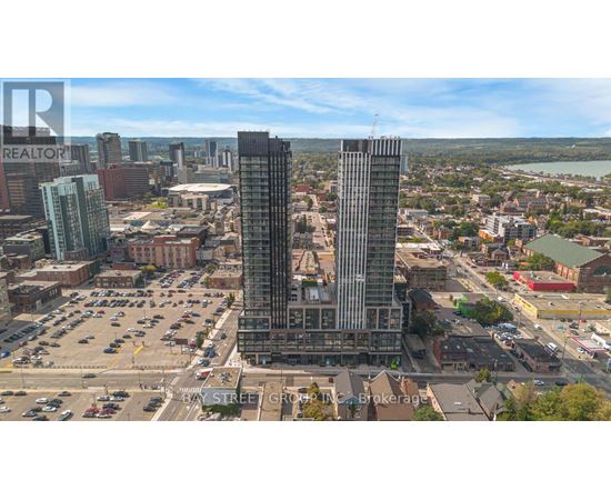 A cityscape with a large building in the center and a parking lot in the foreground.