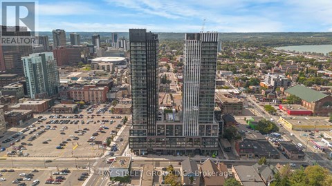 A cityscape with a large building in the center and a parking lot in the foreground.