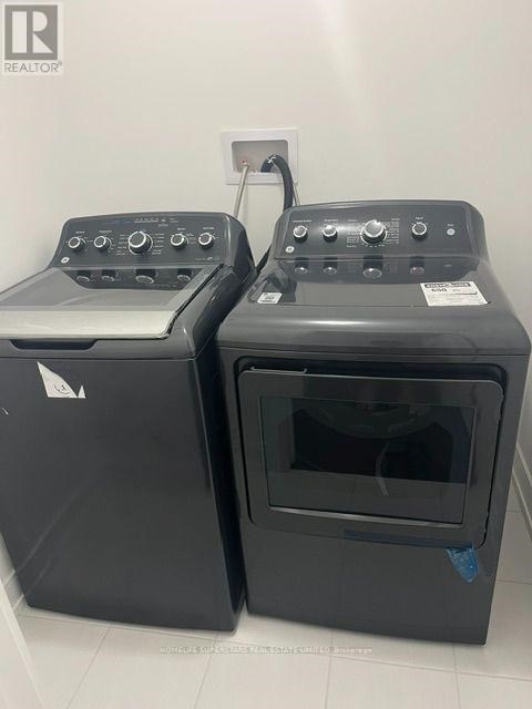 Two black ovens with control panels on top are in a white room.