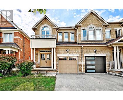 A large, two-story house with a garage and a driveway.
