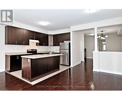 A kitchen with dark wood cabinets and a white island.
