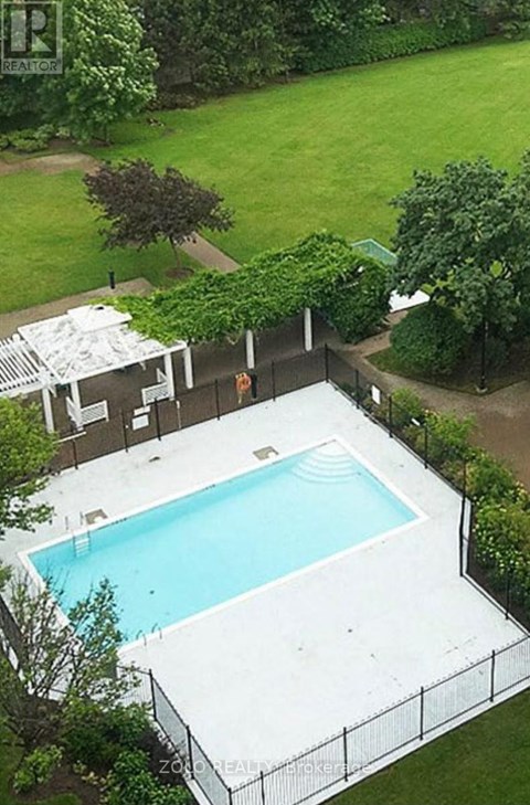 A pool surrounded by a fence and trees.