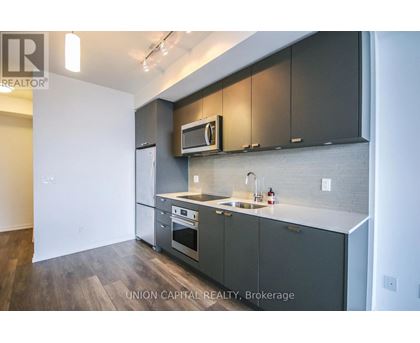 A kitchen with dark grey cabinets and a white countertop.