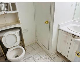 A bathroom with a toilet, sink, and medicine cabinet.