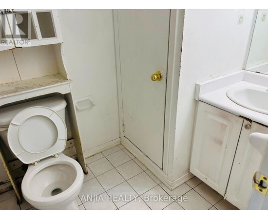 A bathroom with a toilet, sink, and medicine cabinet.